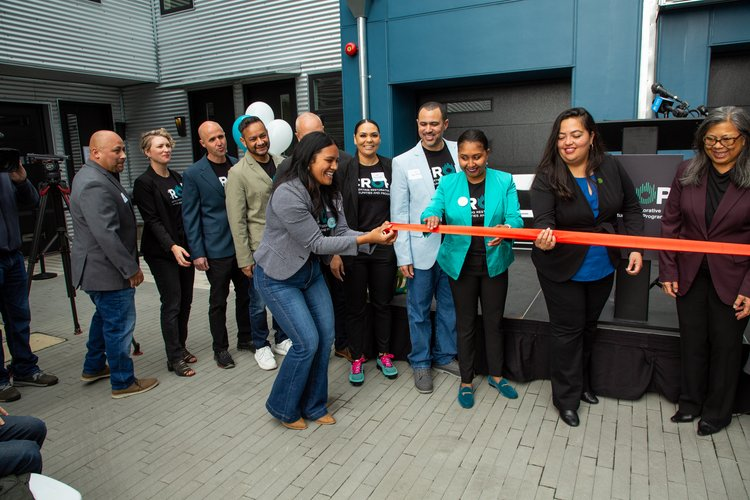 CROP staff member cutting the ribbon along with other leadership, lawmakers, and other supporters of CROP for the 'groundbreaking' of the new campus and learning center in Oakland